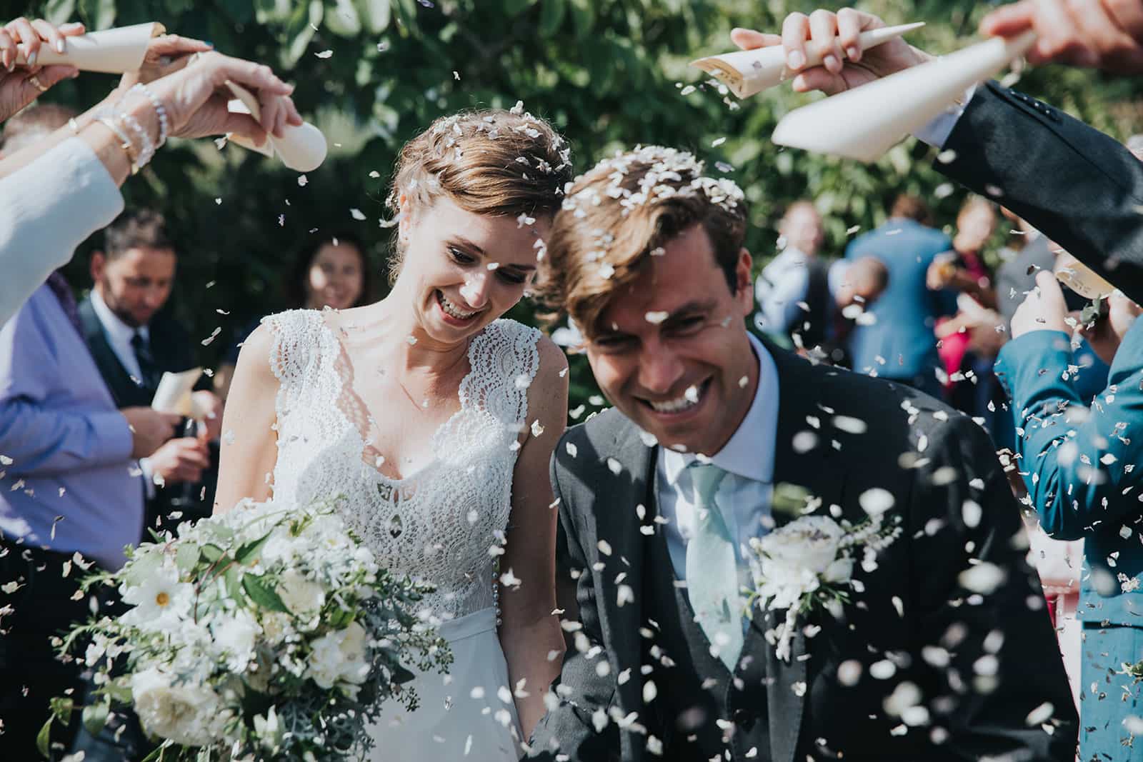 A photograph of newly weds and confetti being thrown at their tropical garden wedding
