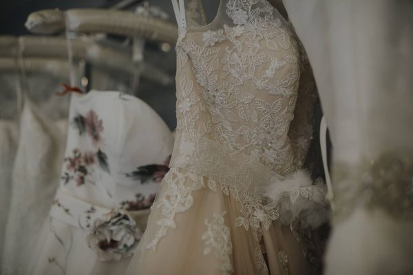 A photograph of beautiful wedding gowns hanging in a row at a bridal studio